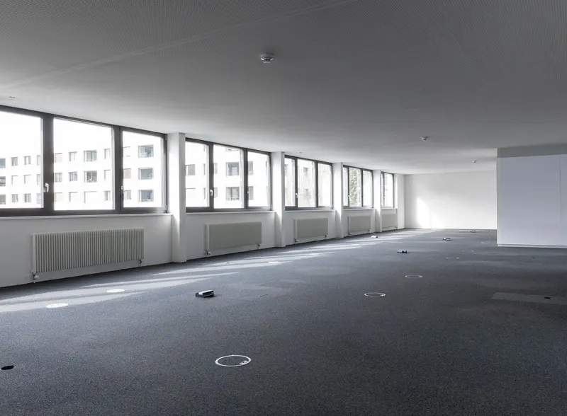 Leere Büroetage mit Fensterreihe und Teppichboden
